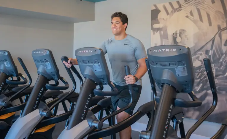a man using an elliptical in a gym