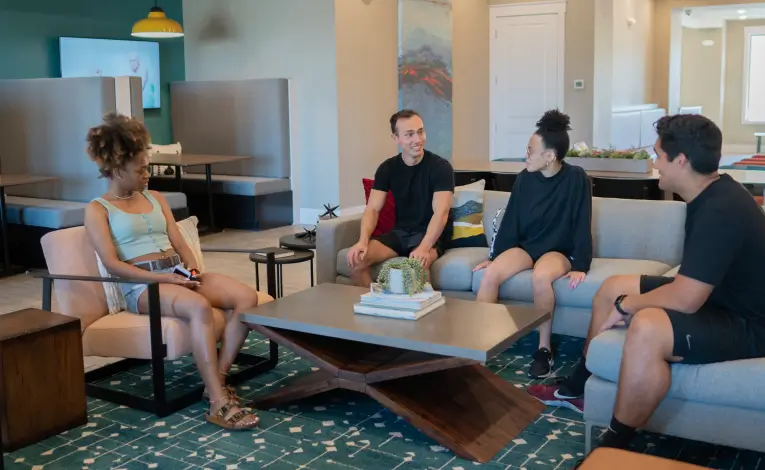 a group of young adults sitting in a resident lounge