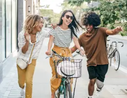 three women biking and walking outside